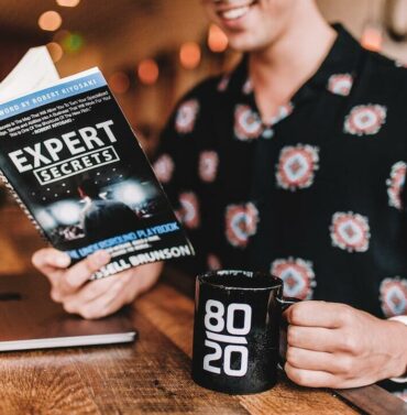 Confident young professional man smiling in a modern office setting, wearing business casual attire
