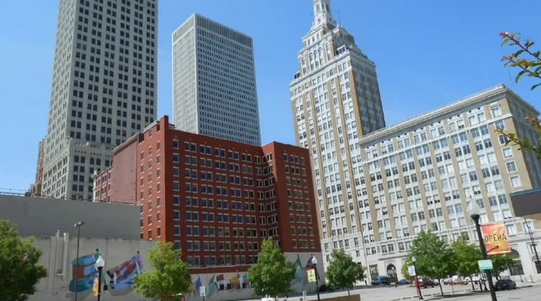 Downtown Tulsa, Oklahoma skyline with modern buildings, the Tulsa Performing Arts Center, and the Arkansas River in the background