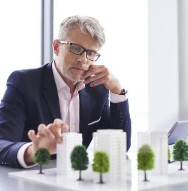 Discover a busy businessman reviewing real estate solutions, illustrating strategic planning for property investments in Oklahoma.